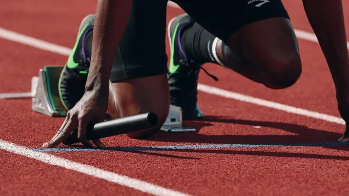 Athlète sur les starting blocks se préparant au départ de sa course.