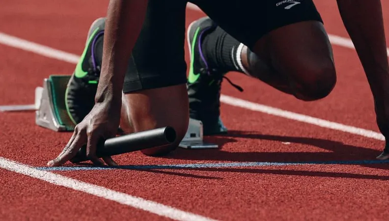 Athlète sur les starting blocks se préparant au départ de sa course.